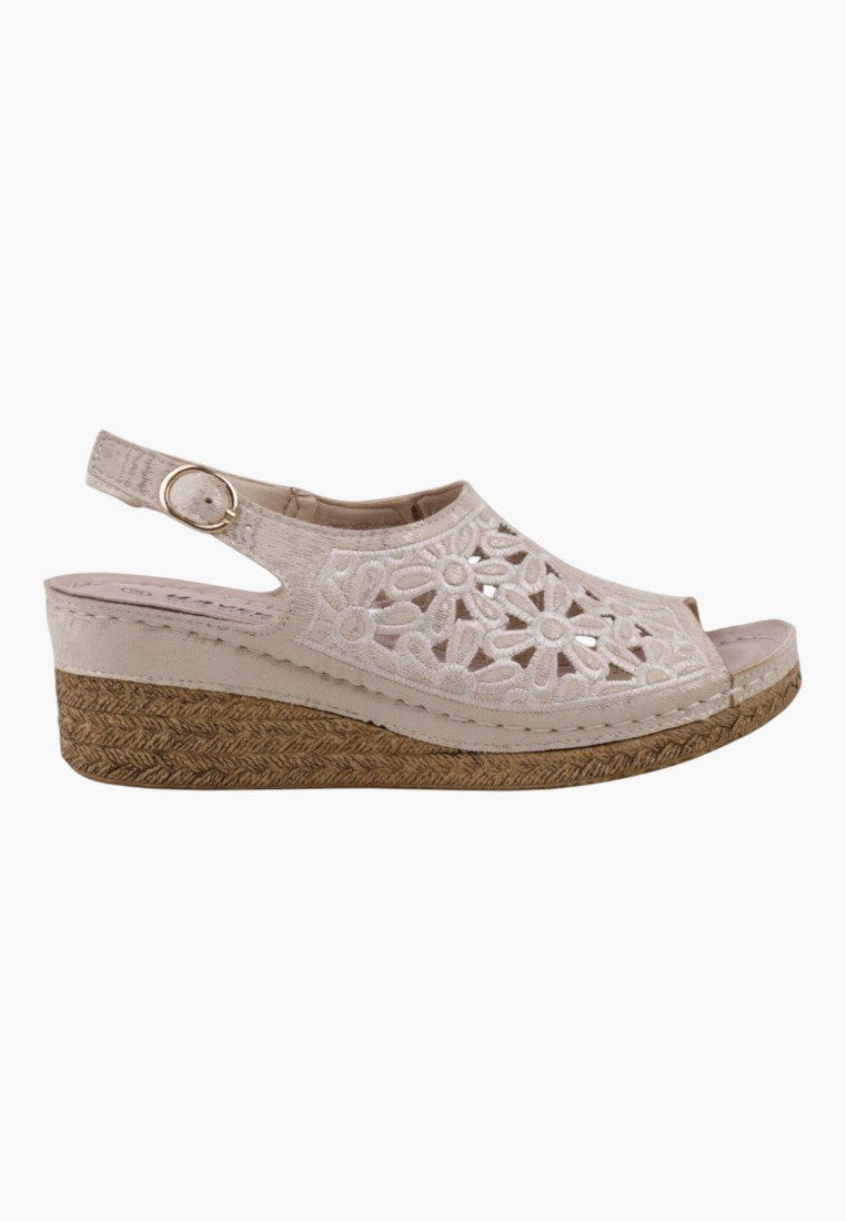 Side view of beżowych sandałów damskich na koturnie z zapięciem typu slingback i koturnem.