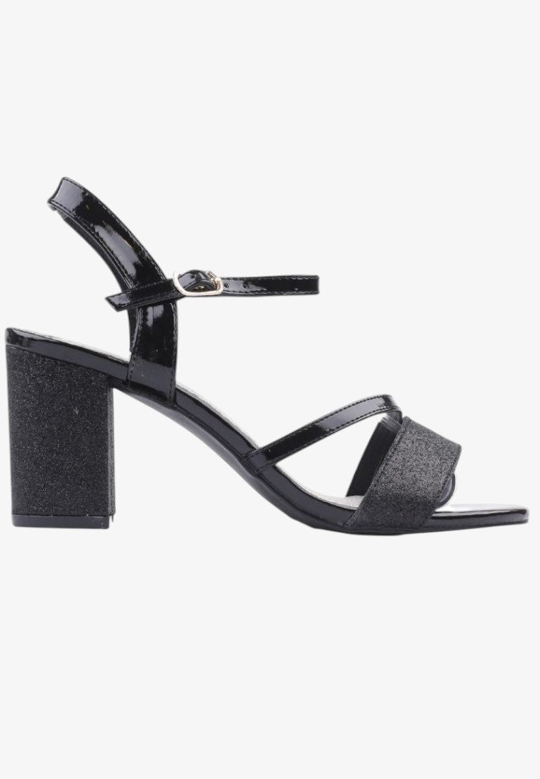 Boczne ujęcie czarnych sandałów damskich na słupku z ankle strap na białym tle