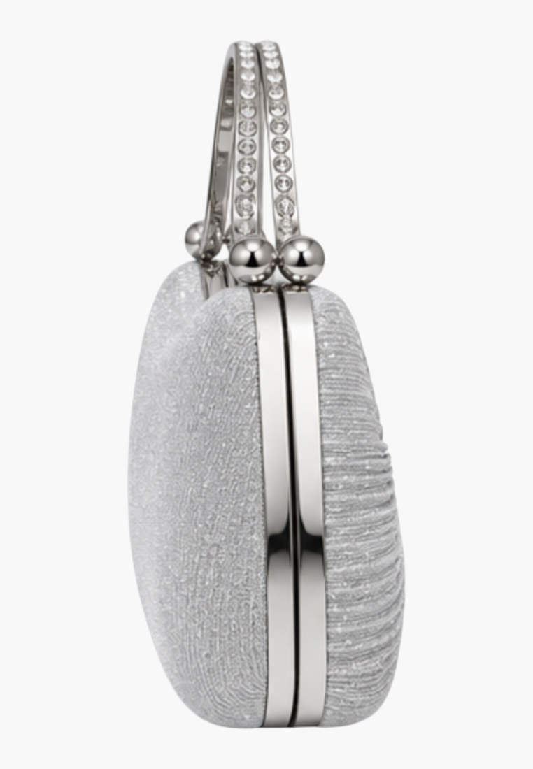 Side view of the srebrnej torebki kopertówki z gładką teksturą i metalowym uchwytem.