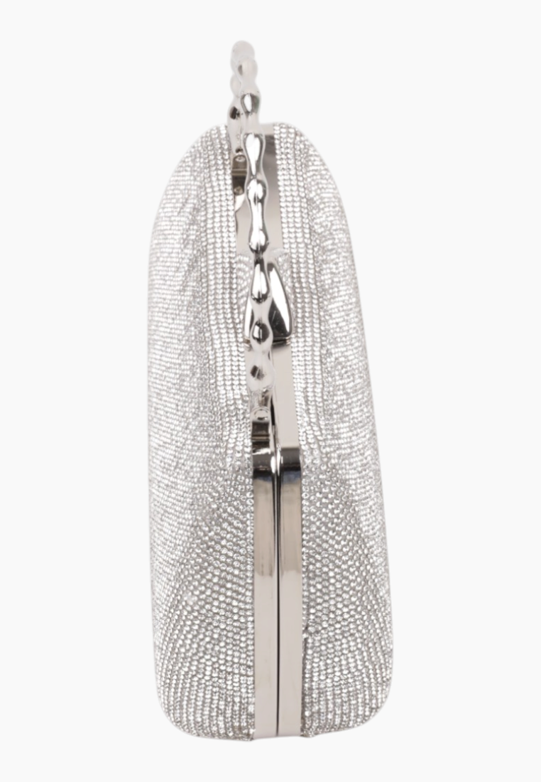 Side view of the silver clutch bag featuring a rounded shape and zipper closure.