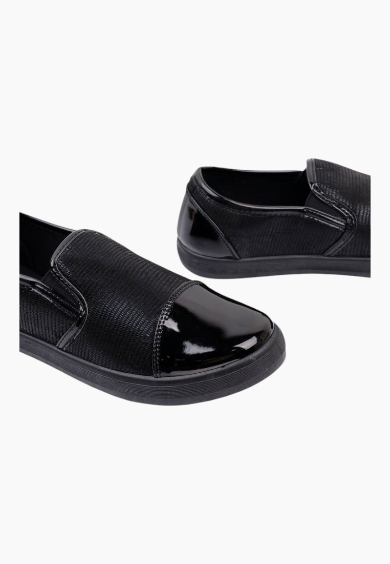 Detail close-up of black slip-on shoes with textured upper and elastic band.