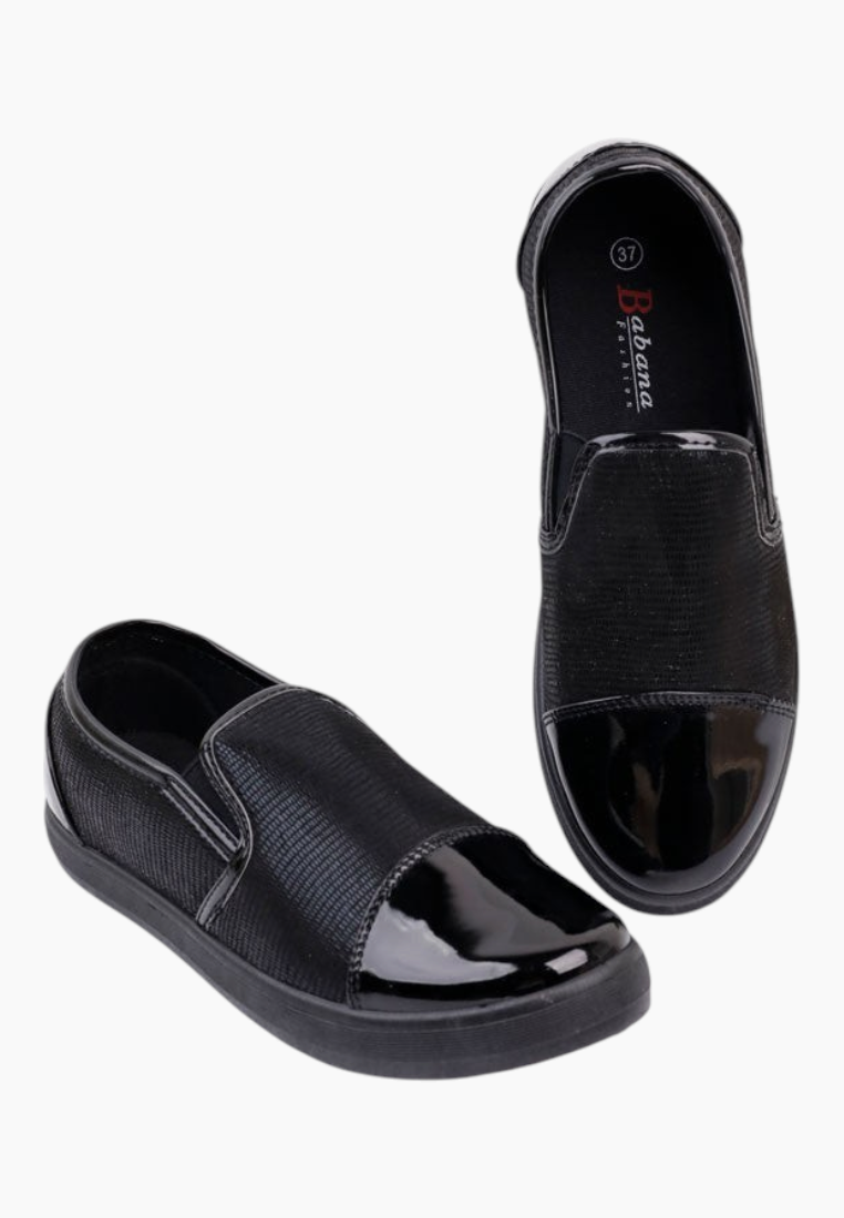 Lifestyle shot of black slip-on shoes with shiny finish and casual style.