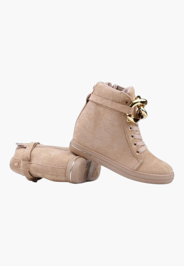 Szczegółowy widok beżowych sneakersów z złotym łańcuchem
