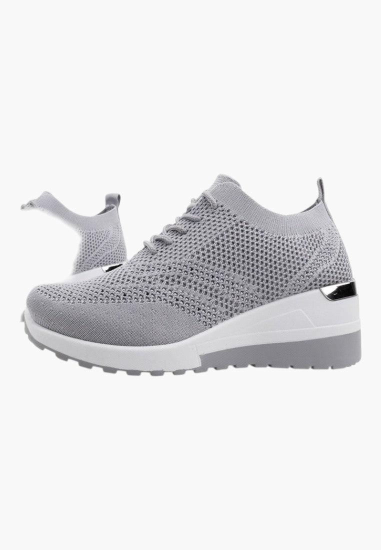 Stylizacja szarych sneakersów damskich, wygodny krój na naturalnym tle.