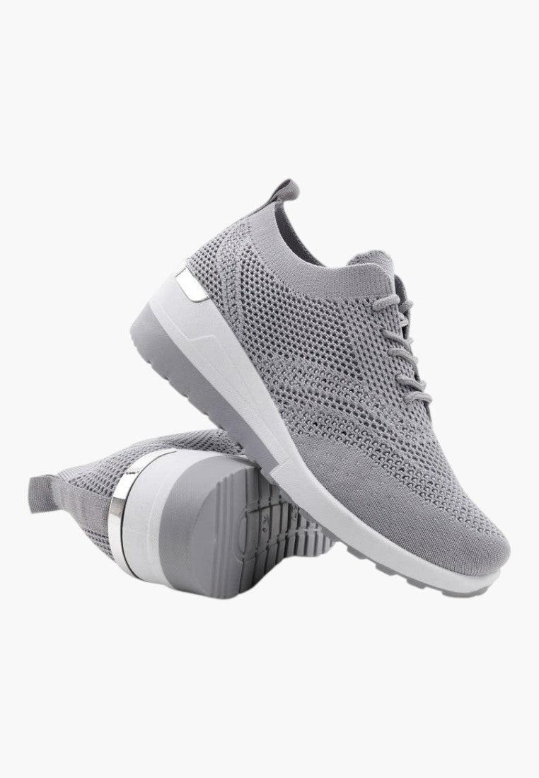 Widok z boku szarych sneakersów damskich z siateczkowym wierzchem.