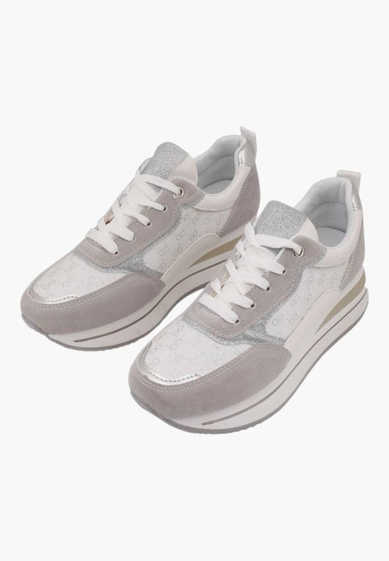 Szczegółowy widok na szaro-białe sneakersy z teksturowanym materiałem.