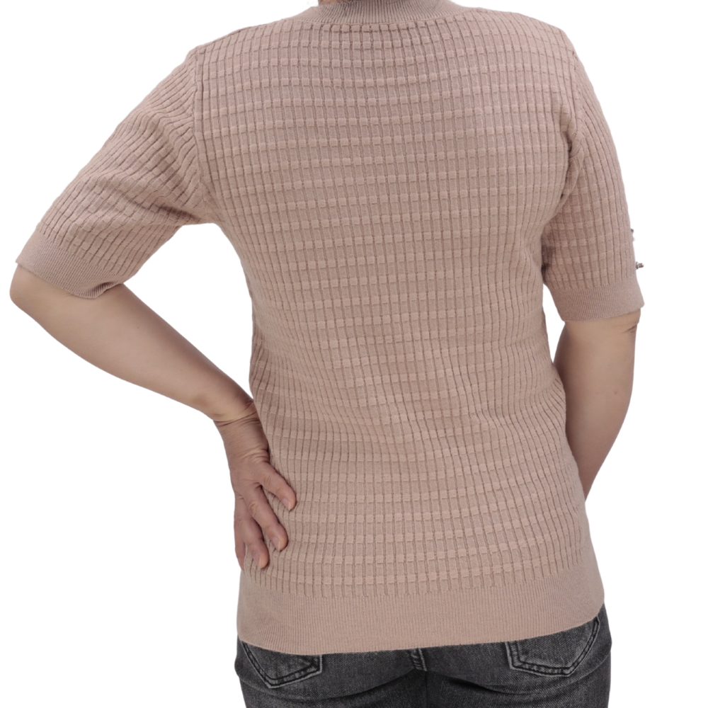 Side view of a light pink top highlighting short sleeves and textured fabric.