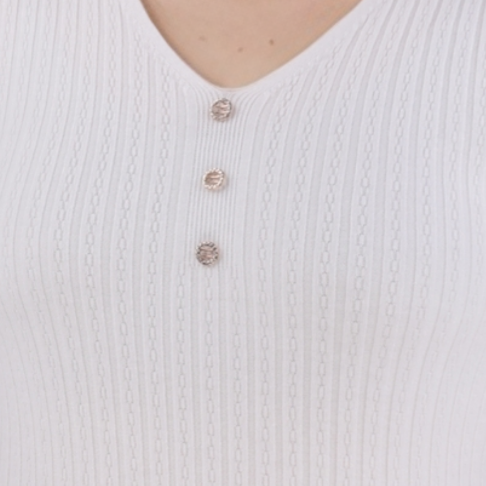 Detail view of the white ribbed top showing button details and ribbed texture.