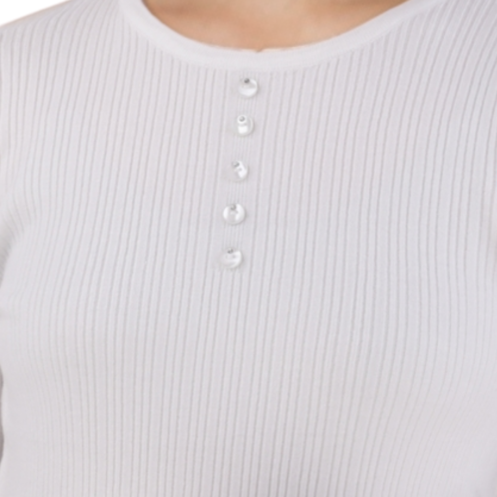Detail close-up of the white ribbed sweter showcasing button details.