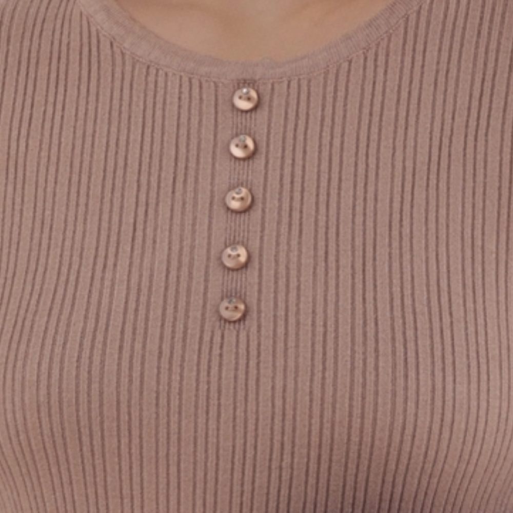 Detail view of the różowy sweter damski z guzikami i teksturą prążkowaną.