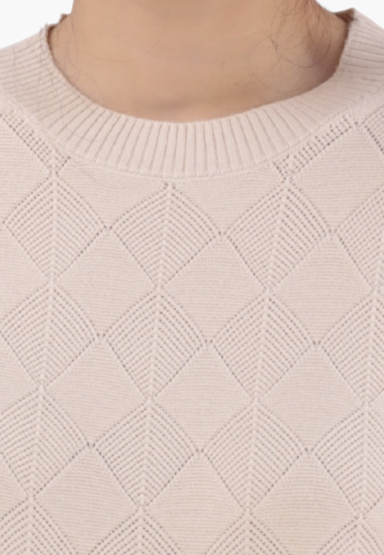 Detail close-up of the beżowy sweter z teksturowanym materiałem i wzorem diamentowym na białym tle.