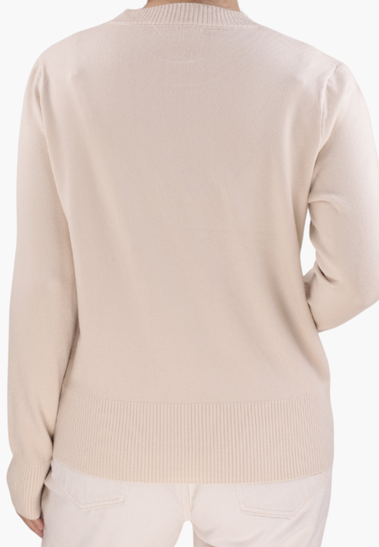 Side view of the beżowy sweter z długim rękawem i teksturowanym wzorem na białym tle.