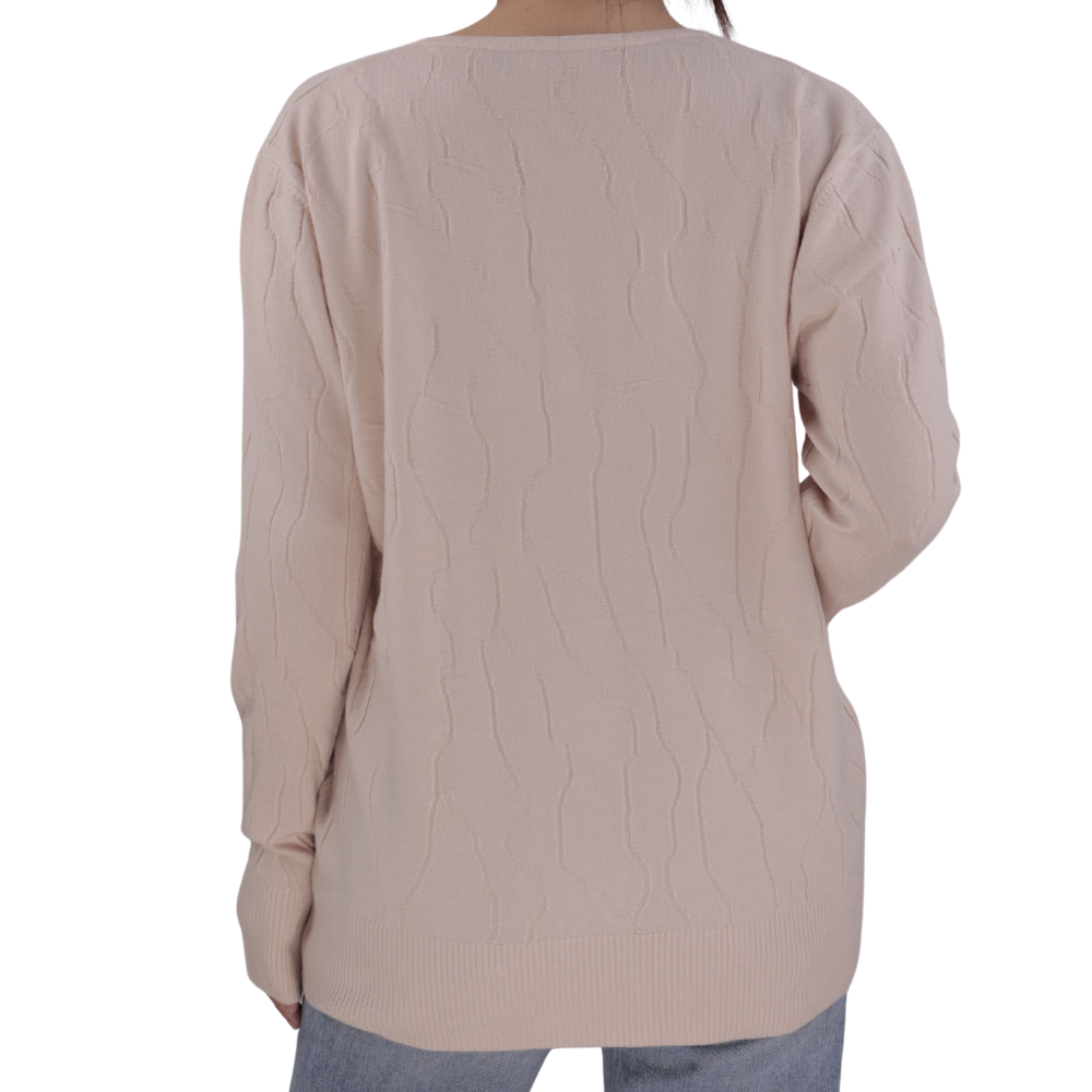 Side view of the light beige long sleeve sweter featuring button details.