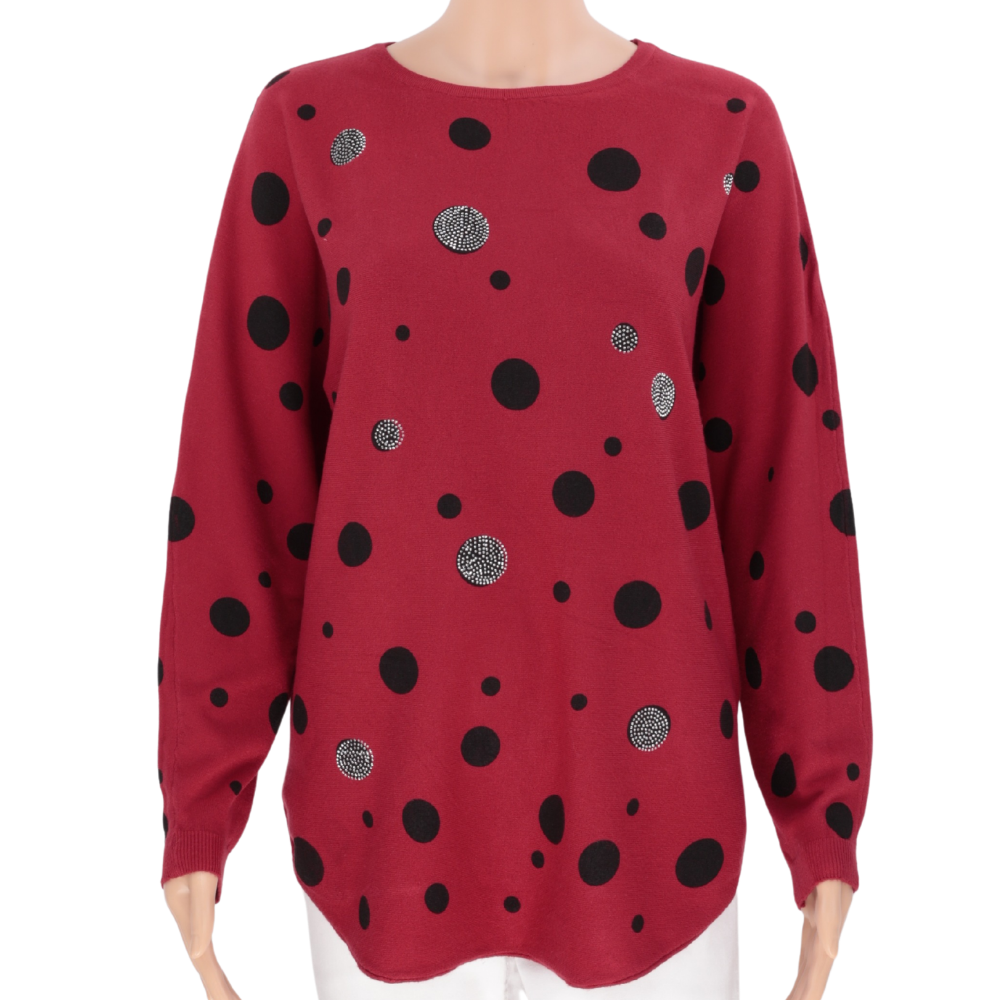 Lifestyle shot of a black polka dot sweater with long sleeves and round neckline.