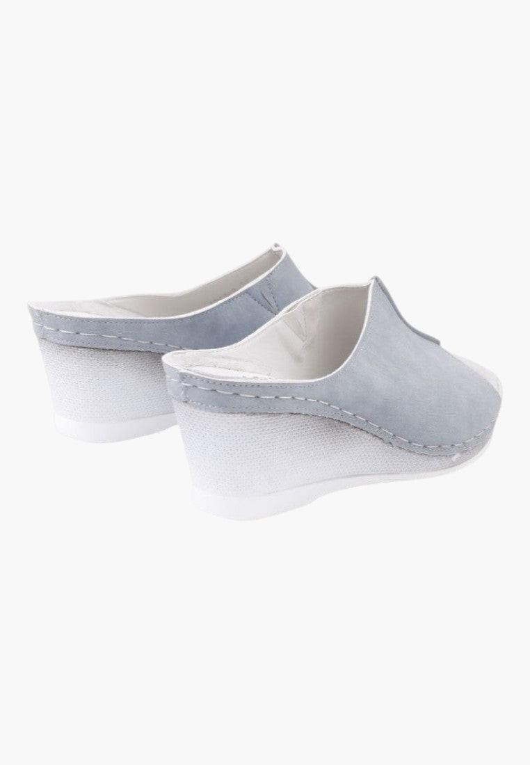 Szczegółowy widok szarych klapków slip-on z zaokrąglonym noskiem.