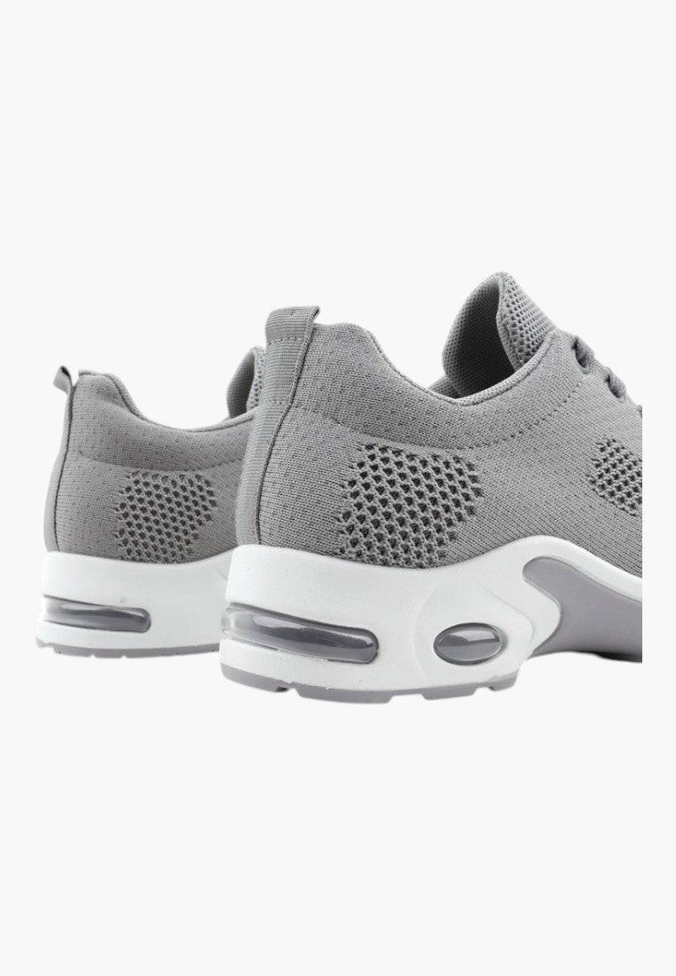 Widok z tyłu szarych sportowych sneakersów z białą podeszwą.