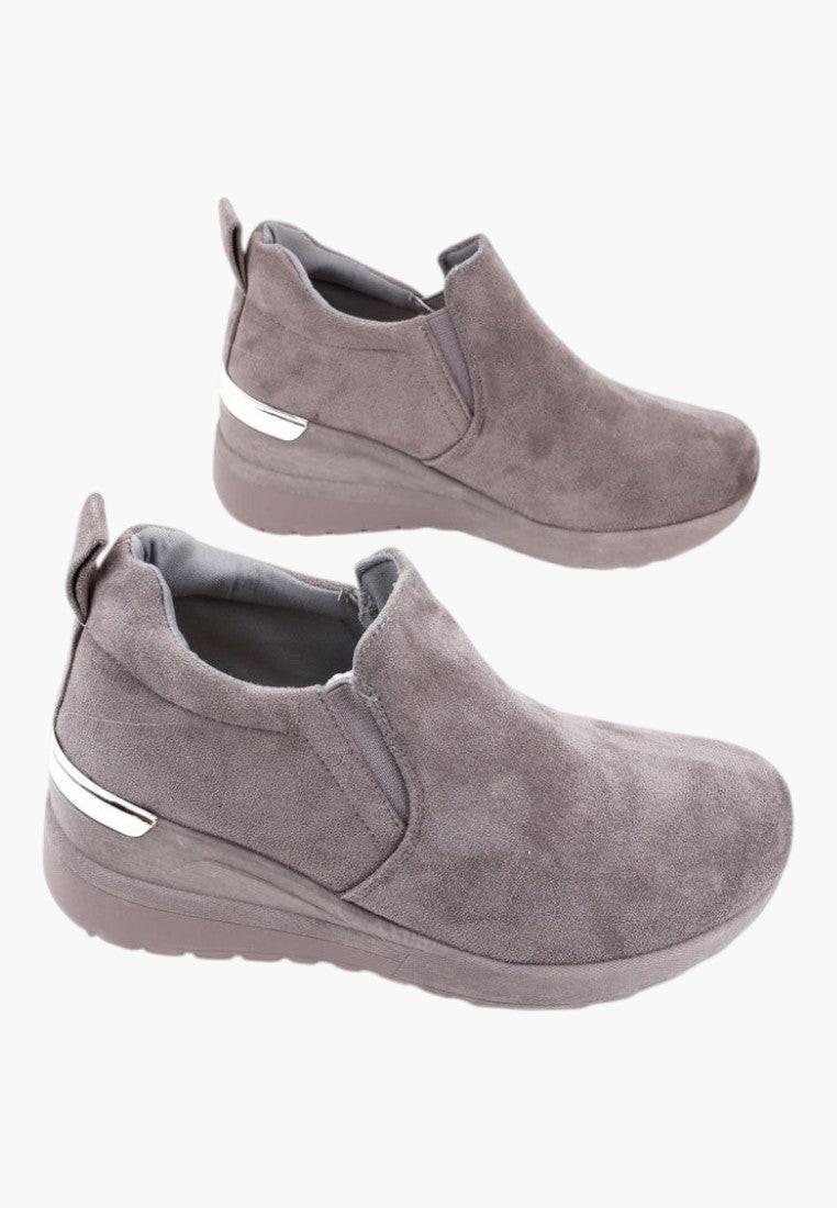 Zbliżenie na materiał szarych sneakersów damskich zamszowych z okrągłym noskiem.