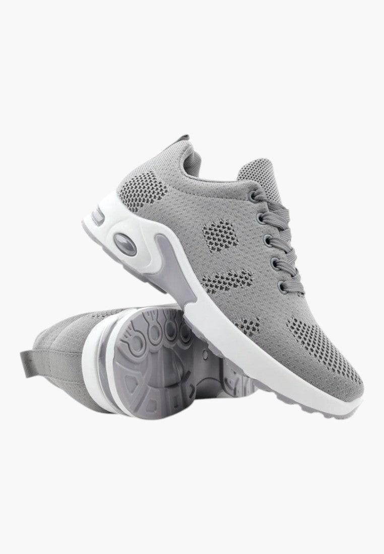 Szare sportowe sneakersy z gumową podeszwą, widok lifestyle.
