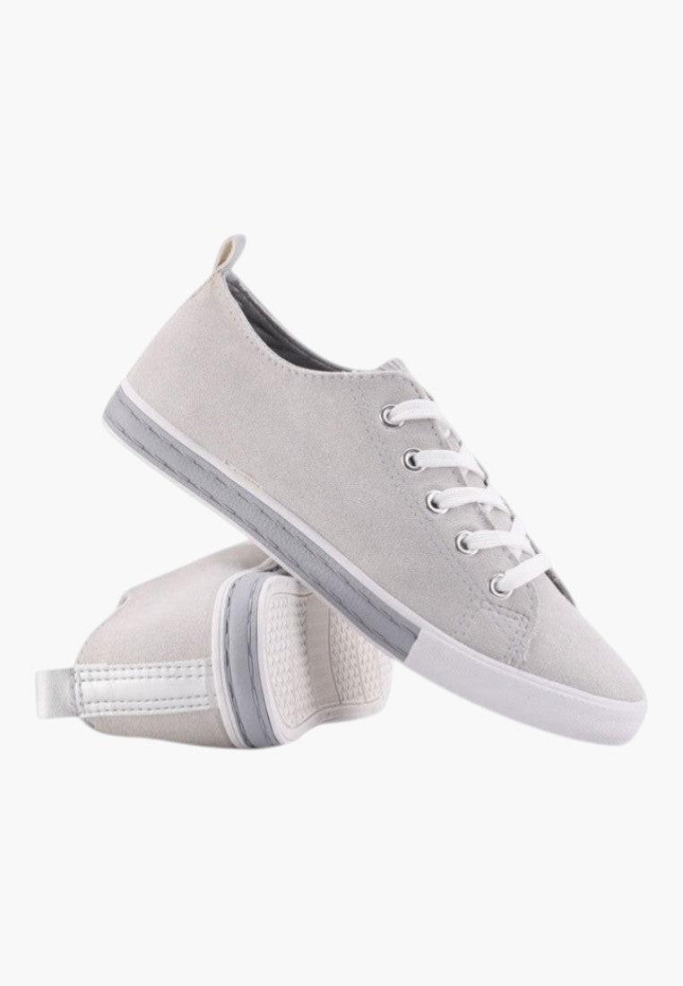 Lifestyle view of gray eco-suede sneakers with lace-up design.