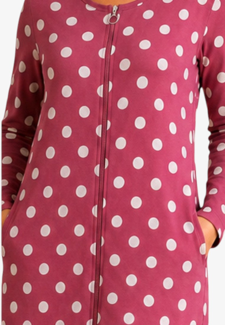 Detail view of a deep pink cotton robe with white polka dots and button closure.