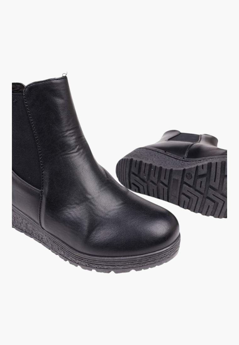 Detail view of black ankle boots highlighting sturdy construction and rubber sole.