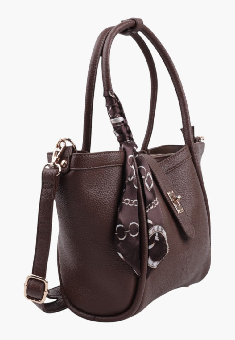 Side view of taupe faux leather shopper bag with shoulder strap and decorative scarf.