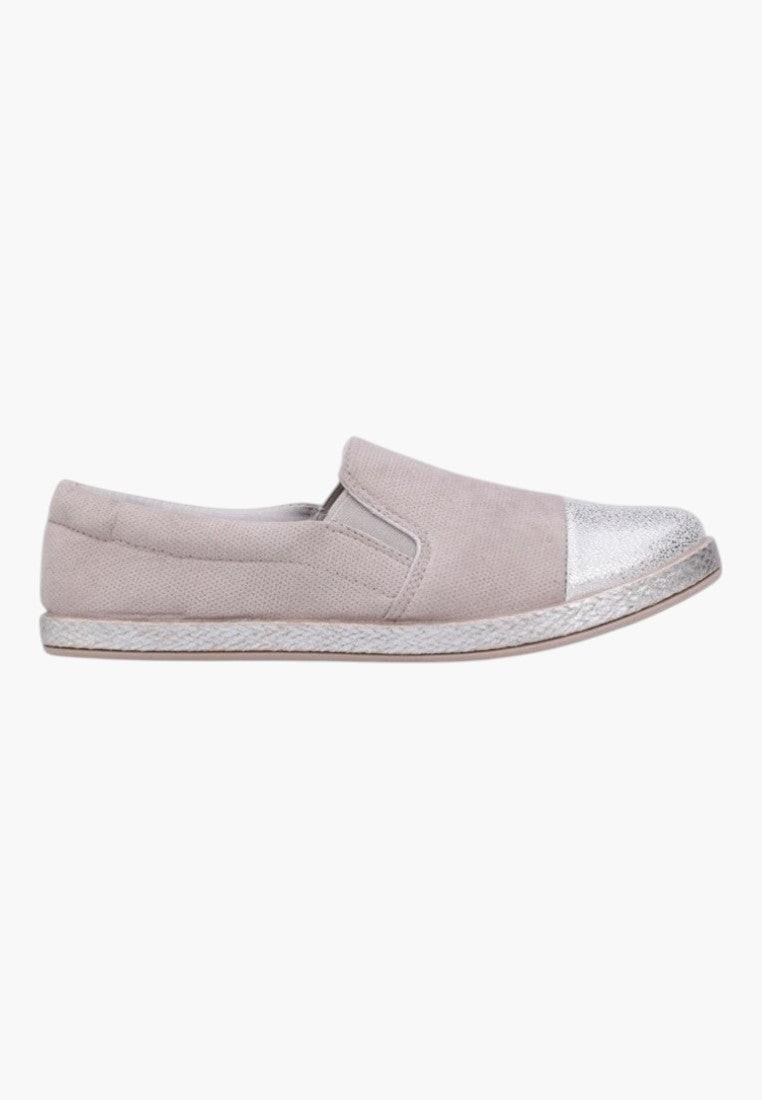 Lifestyle shot of beige slip-on shoes styled with casual wear.