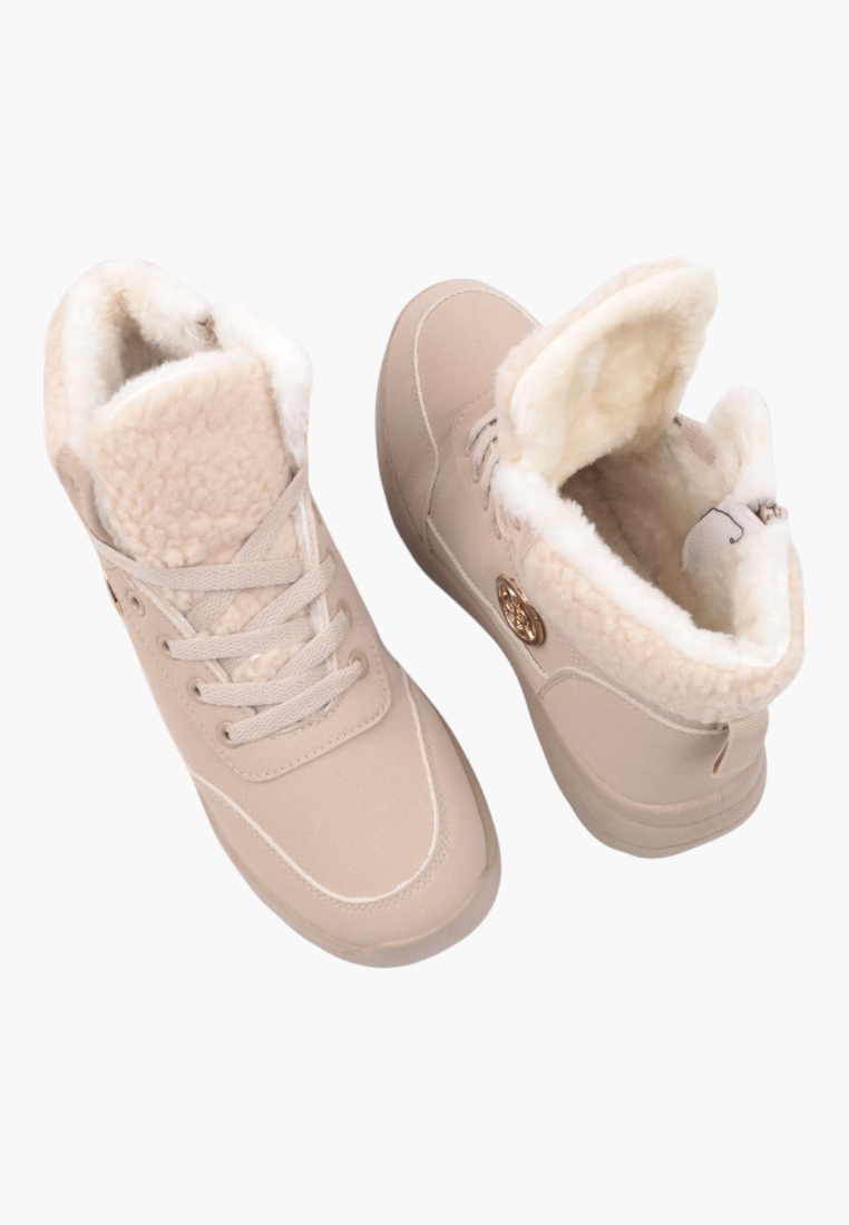 Detail close-up of beige winter boots showing lace-up closure and logo detail.