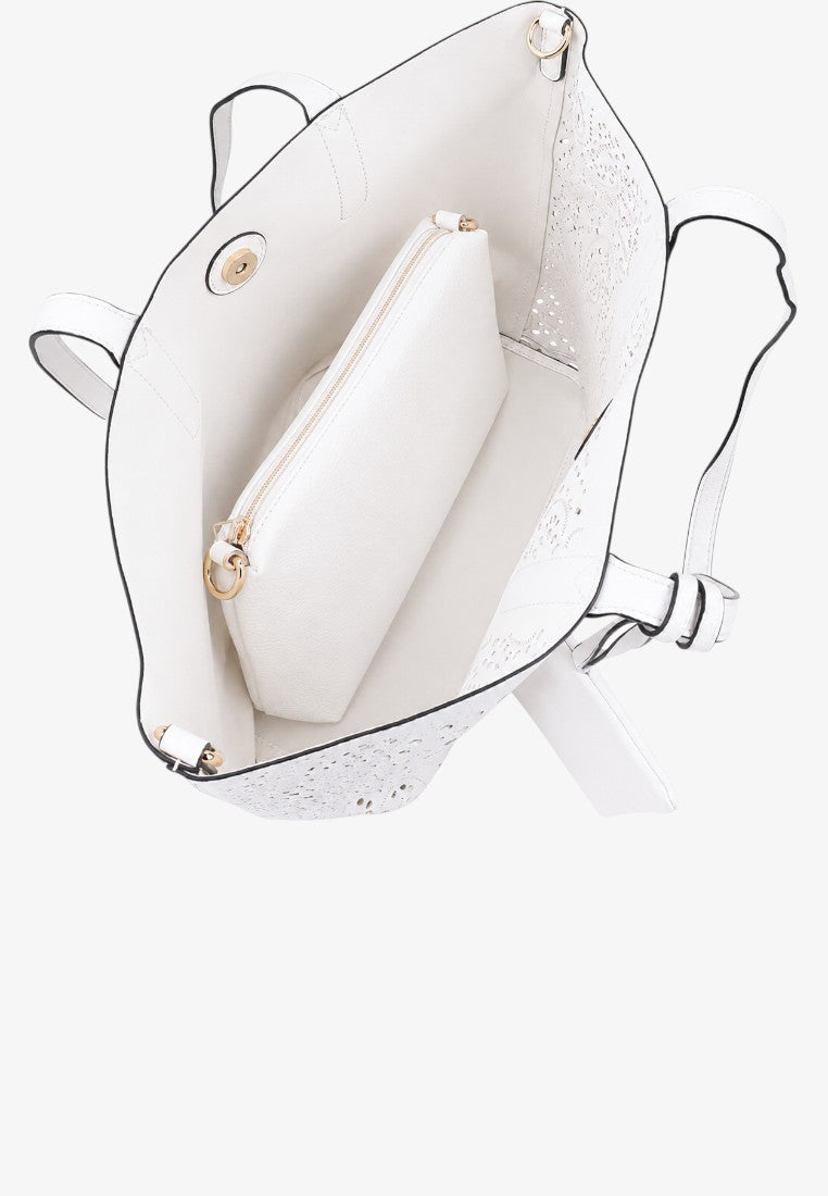 Detail view of the interior of a white handbag showing an inner pocket and gold hardware.