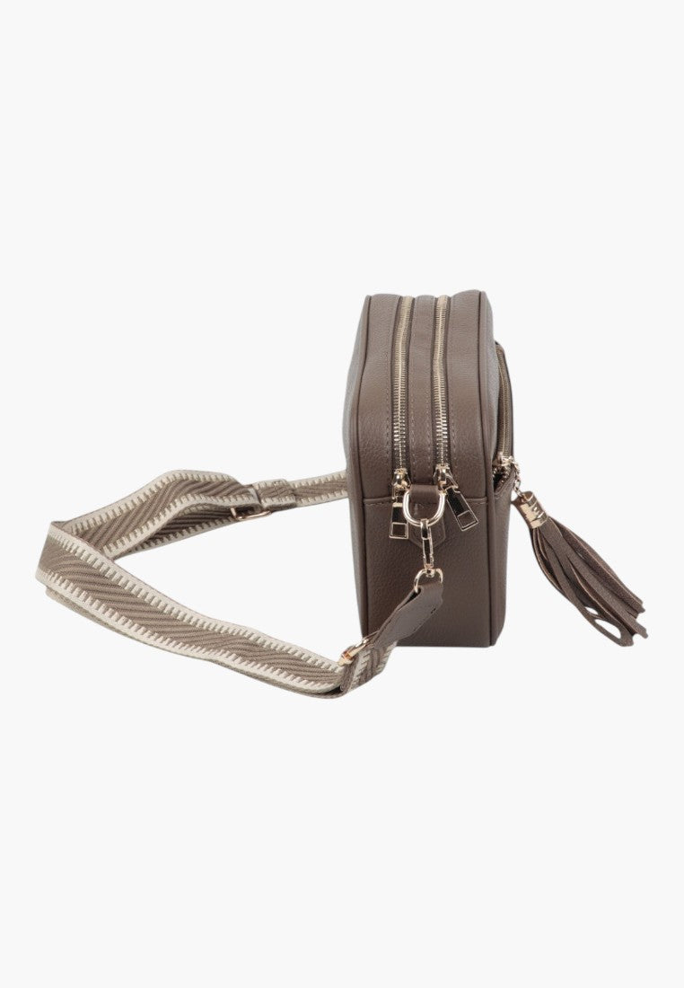 Side view of the wielokolorowa listonoszka damska na ramię featuring zipper closure and tassel detail.