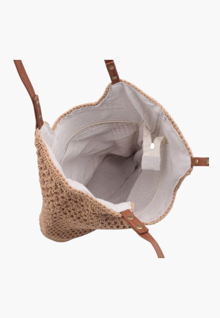 Detail view of the wnętrza wielokolorowej torebki damskiej shopper z jasnym wnętrzem i widoczną metką na białym tle