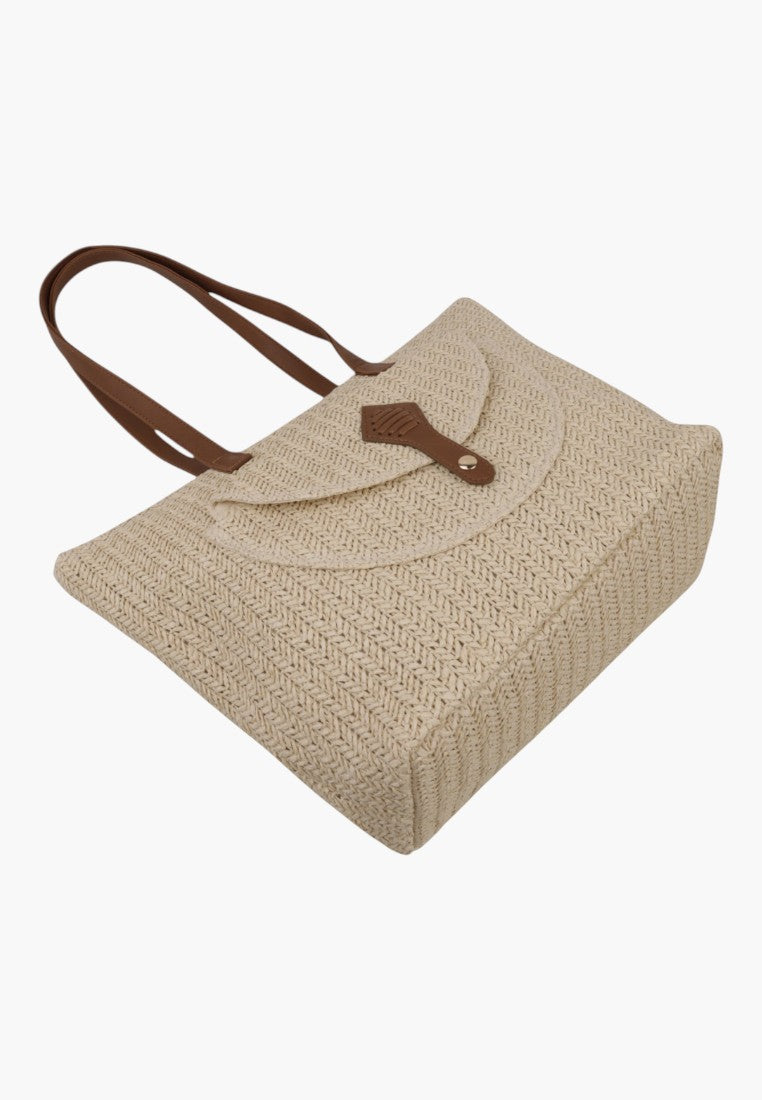 Zbliżenie na szczegóły torebki shopper na ramię, z klapą i zapięciem na guzik.