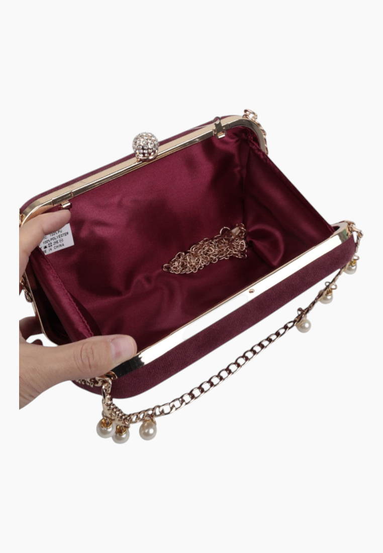 Interior view of the burgundy clutch purse featuring satin lining and gold hardware.