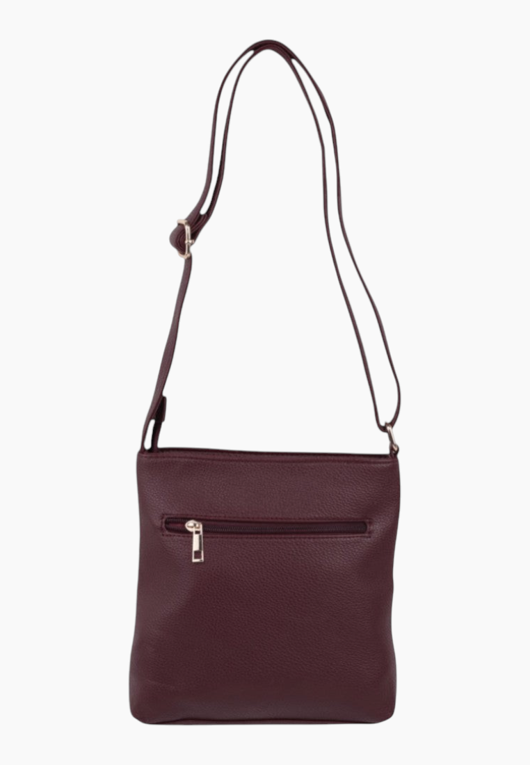 Side view of burgundy quilted handbag with adjustable strap and zipper pockets